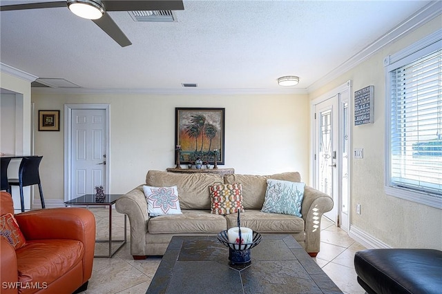 tiled living room with a textured ceiling, ceiling fan, and ornamental molding