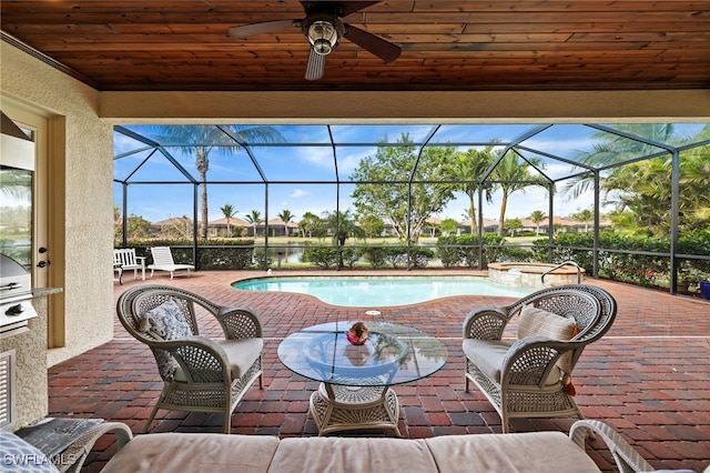 view of swimming pool with a water view, glass enclosure, a patio area, and ceiling fan