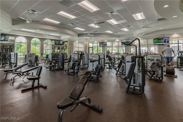 exercise room with ceiling fan and a drop ceiling