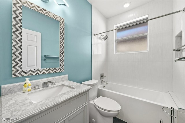 full bathroom featuring vanity, tiled shower / bath combo, and toilet