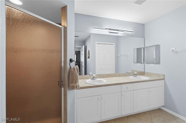 bathroom with tile patterned floors, a shower with door, and vanity