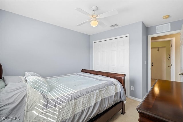 bedroom featuring ceiling fan, light carpet, and a closet