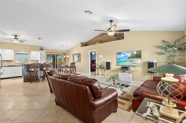 living room with ceiling fan, light tile patterned floors, sink, and vaulted ceiling