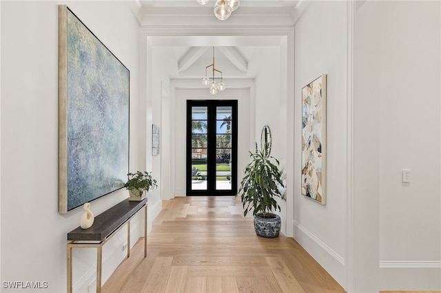 foyer featuring light parquet flooring, beam ceiling, a chandelier, and french doors