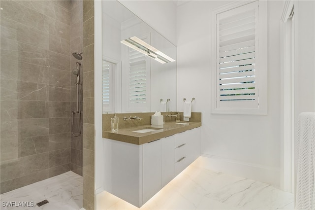 bathroom with a tile shower, vanity, and a wealth of natural light