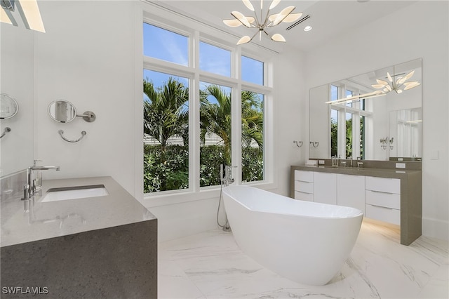 bathroom with vanity, a bath, and a chandelier