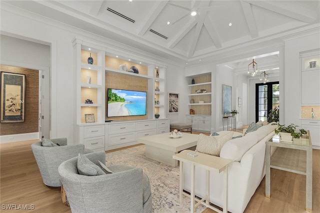 living room featuring crown molding, light hardwood / wood-style flooring, built in features, beamed ceiling, and a chandelier