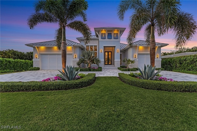 view of front of property with french doors, a yard, and a garage