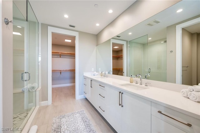 bathroom featuring vanity, wood-type flooring, and an enclosed shower