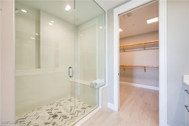 bathroom featuring vanity, a shower with shower door, and hardwood / wood-style flooring