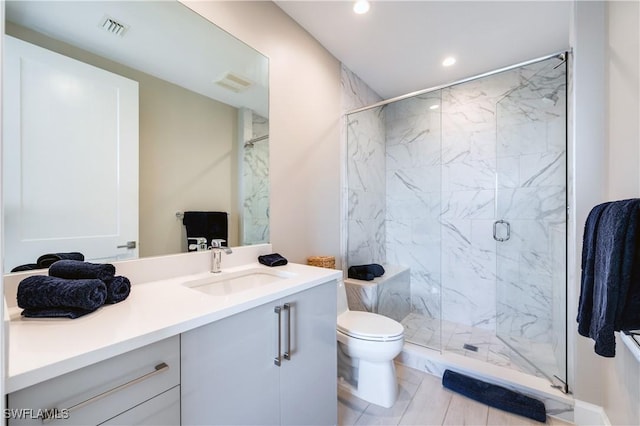 bathroom featuring vanity, toilet, and an enclosed shower