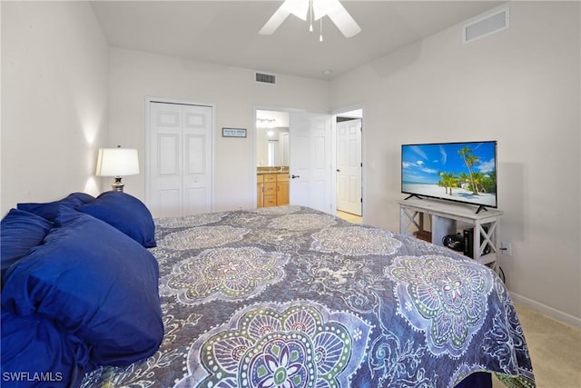 carpeted bedroom featuring a closet, ceiling fan, and ensuite bathroom