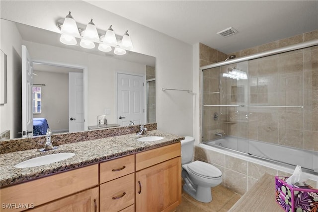 full bathroom featuring tile patterned floors, vanity, toilet, and bath / shower combo with glass door