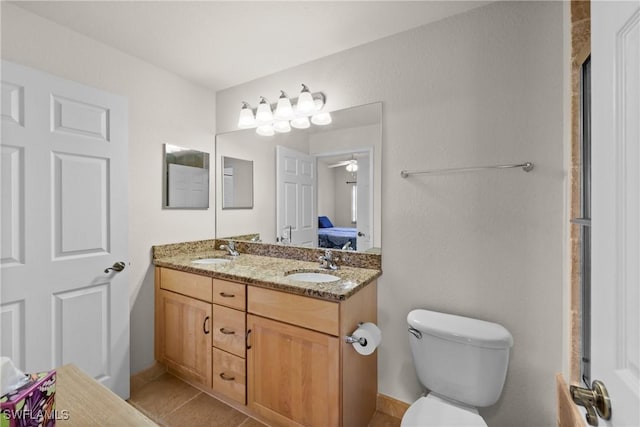 bathroom with tile patterned flooring, vanity, toilet, and ceiling fan