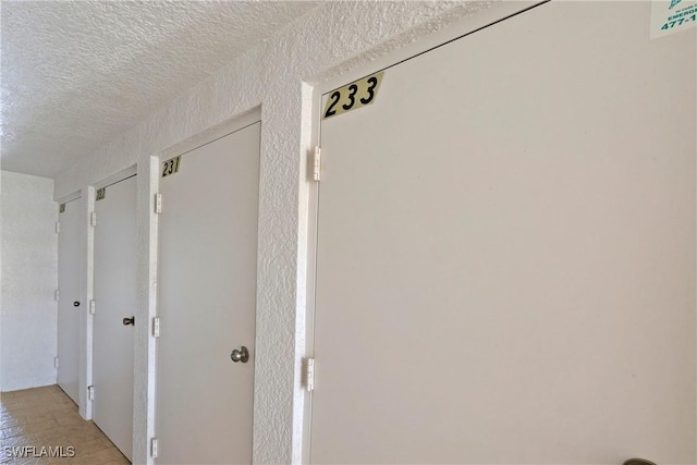 corridor featuring a textured ceiling