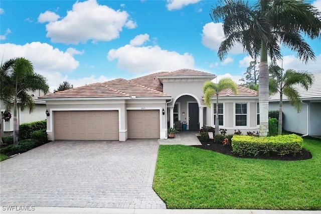 mediterranean / spanish house with a garage and a front yard