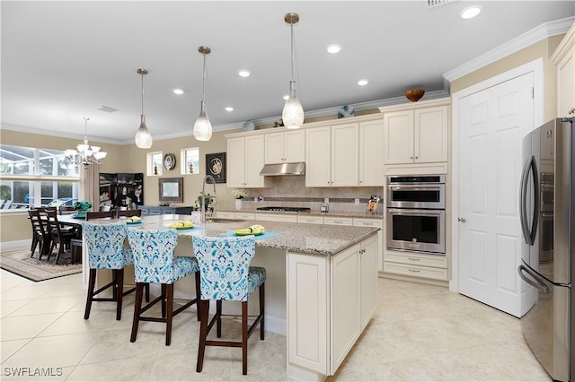 kitchen with crown molding, a kitchen island with sink, pendant lighting, and stainless steel appliances