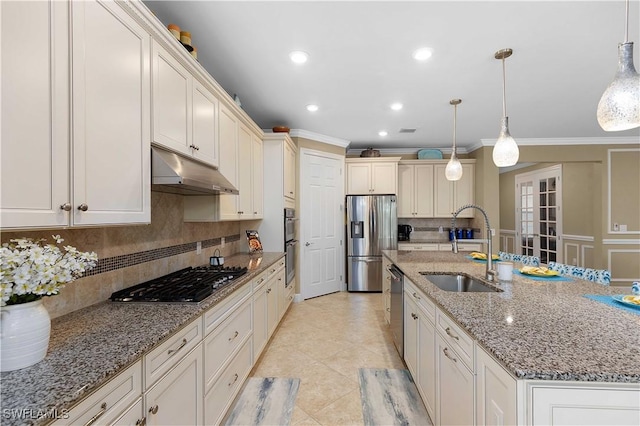 kitchen with a center island with sink, pendant lighting, sink, and stainless steel appliances