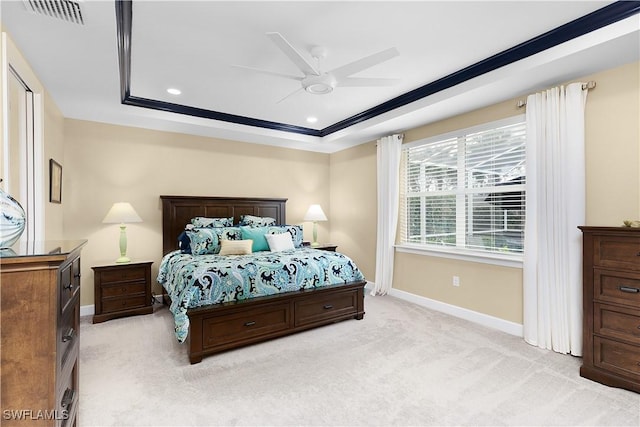 carpeted bedroom with a raised ceiling, ceiling fan, and crown molding