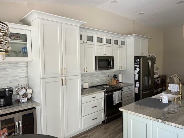 kitchen featuring white cabinets, stainless steel fridge, decorative backsplash, and black / electric stove