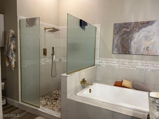 bathroom featuring hardwood / wood-style flooring and independent shower and bath