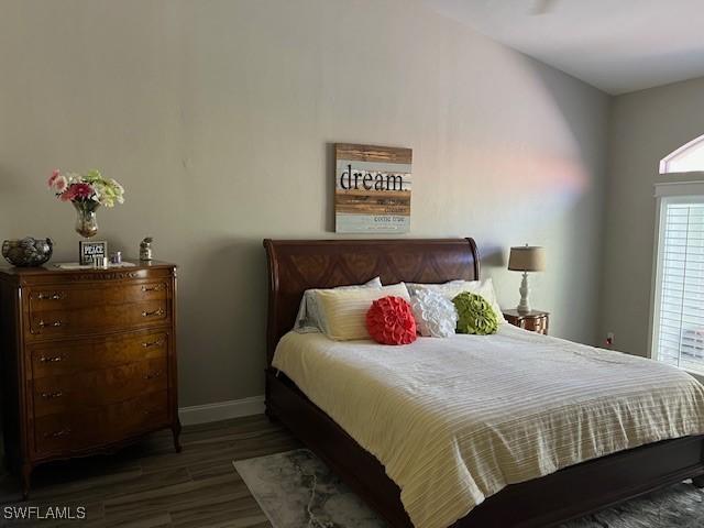 bedroom with dark hardwood / wood-style flooring