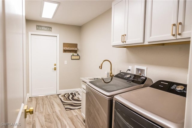 washroom featuring cabinets, washer and dryer, sink, and light wood-type flooring