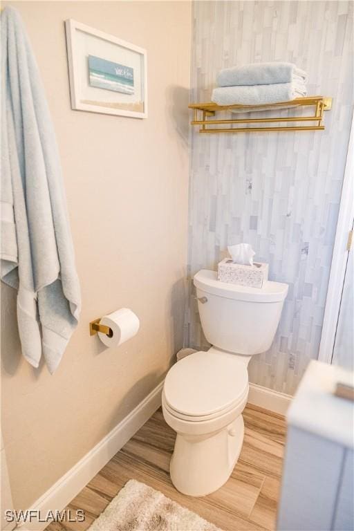 bathroom with hardwood / wood-style flooring and toilet