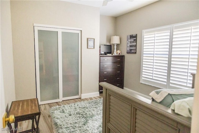 bedroom with ceiling fan, a closet, and light hardwood / wood-style flooring