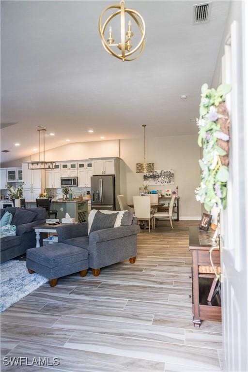 living room featuring lofted ceiling and a notable chandelier