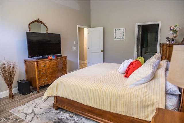 bedroom with connected bathroom and light wood-type flooring