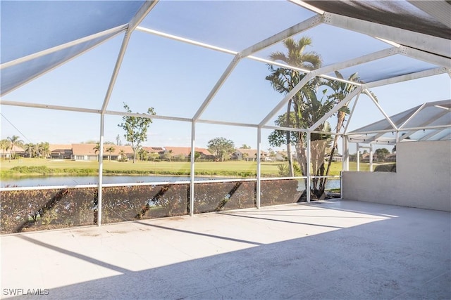 view of patio / terrace featuring a water view and glass enclosure