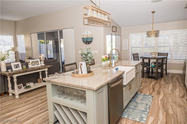 kitchen with hanging light fixtures, sink, stainless steel dishwasher, and an island with sink