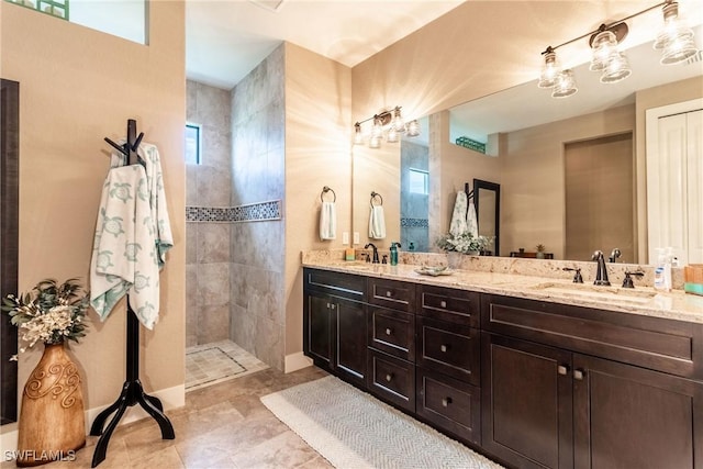 bathroom with vanity, tile patterned flooring, and a tile shower