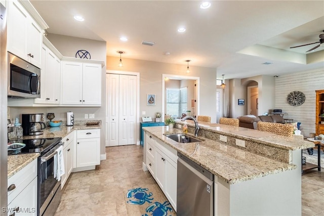 kitchen featuring sink, ceiling fan, a kitchen island with sink, white cabinetry, and stainless steel appliances