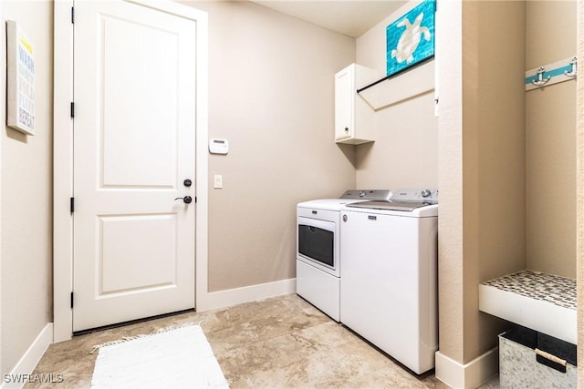 washroom with cabinets and washing machine and clothes dryer