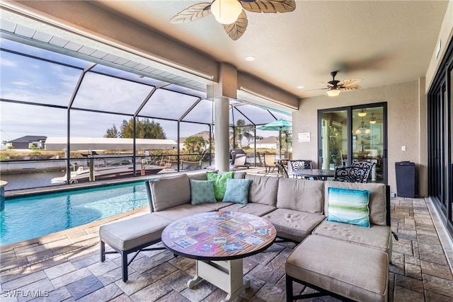 patio terrace at dusk featuring a lanai, outdoor lounge area, and ceiling fan