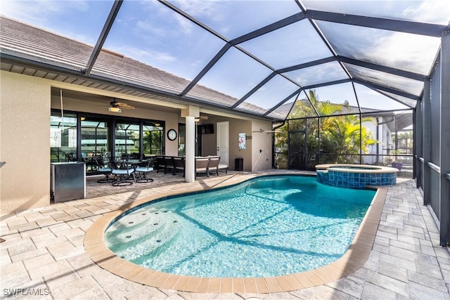 view of swimming pool with an in ground hot tub, ceiling fan, glass enclosure, and a patio