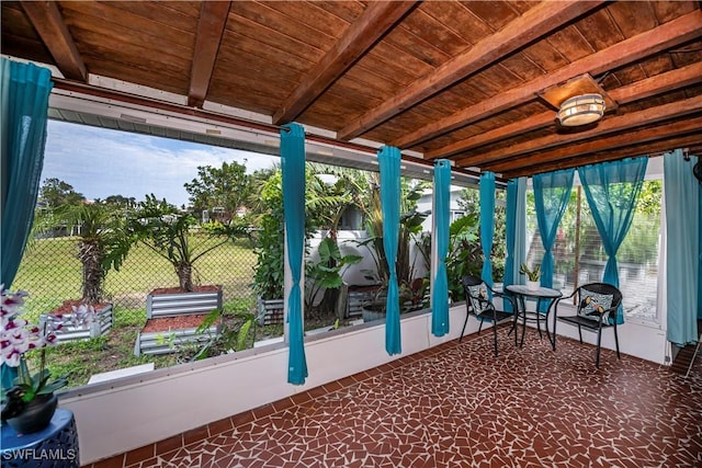 unfurnished sunroom featuring beamed ceiling and wooden ceiling