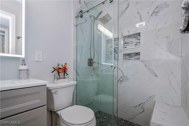 bathroom with vanity, toilet, and a shower with shower door