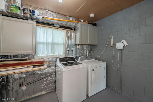 clothes washing area featuring cabinets, separate washer and dryer, and wood ceiling