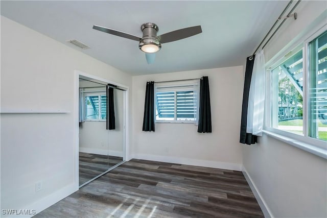 unfurnished bedroom with ceiling fan, multiple windows, and a closet