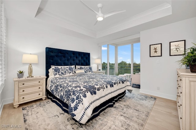 bedroom featuring a tray ceiling, light hardwood / wood-style flooring, and ceiling fan