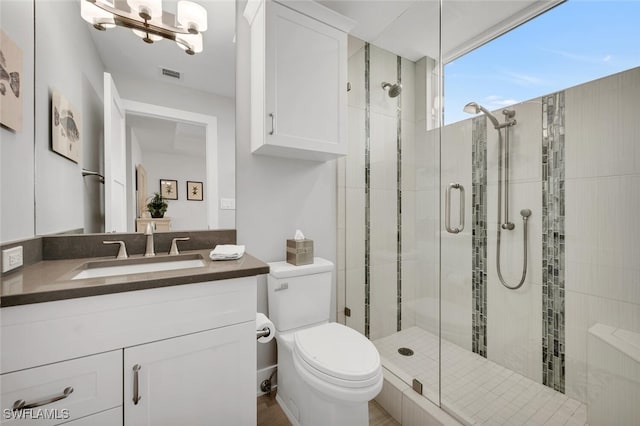 bathroom with vanity, an enclosed shower, and toilet