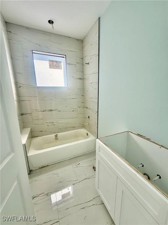 bathroom featuring tiled shower / bath