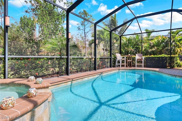 view of pool with pool water feature and glass enclosure