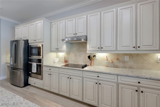 kitchen with backsplash, under cabinet range hood, ornamental molding, appliances with stainless steel finishes, and white cabinets