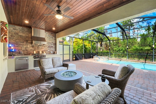 view of patio featuring an outdoor living space with a fire pit, exterior kitchen, glass enclosure, and grilling area