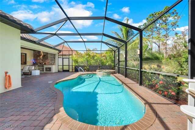 view of swimming pool with a patio, a pool with connected hot tub, and a lanai