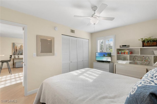 bedroom with ceiling fan, light hardwood / wood-style floors, and a closet